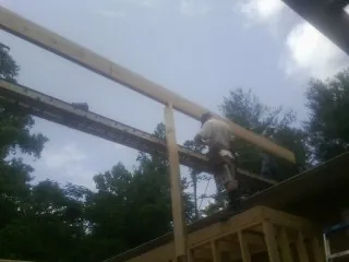 Carpenter setting a ridge beam over a new addition frame — Ice Dam Removal by Roofing Brothers in Collingswood