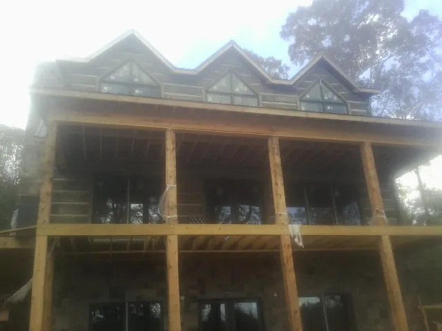 Dormers and porch framing on a large log home under construction — Roof Coating work by our crew in Collingswood